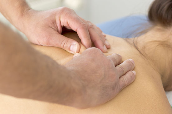 klassicher Massage-Griff am Rücken der Patientin